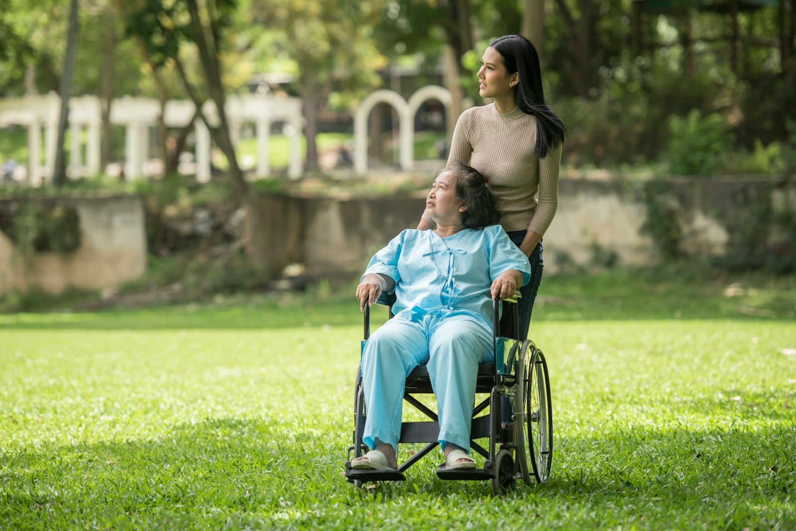 A woman using a wheelchair and a man laughing together in a park