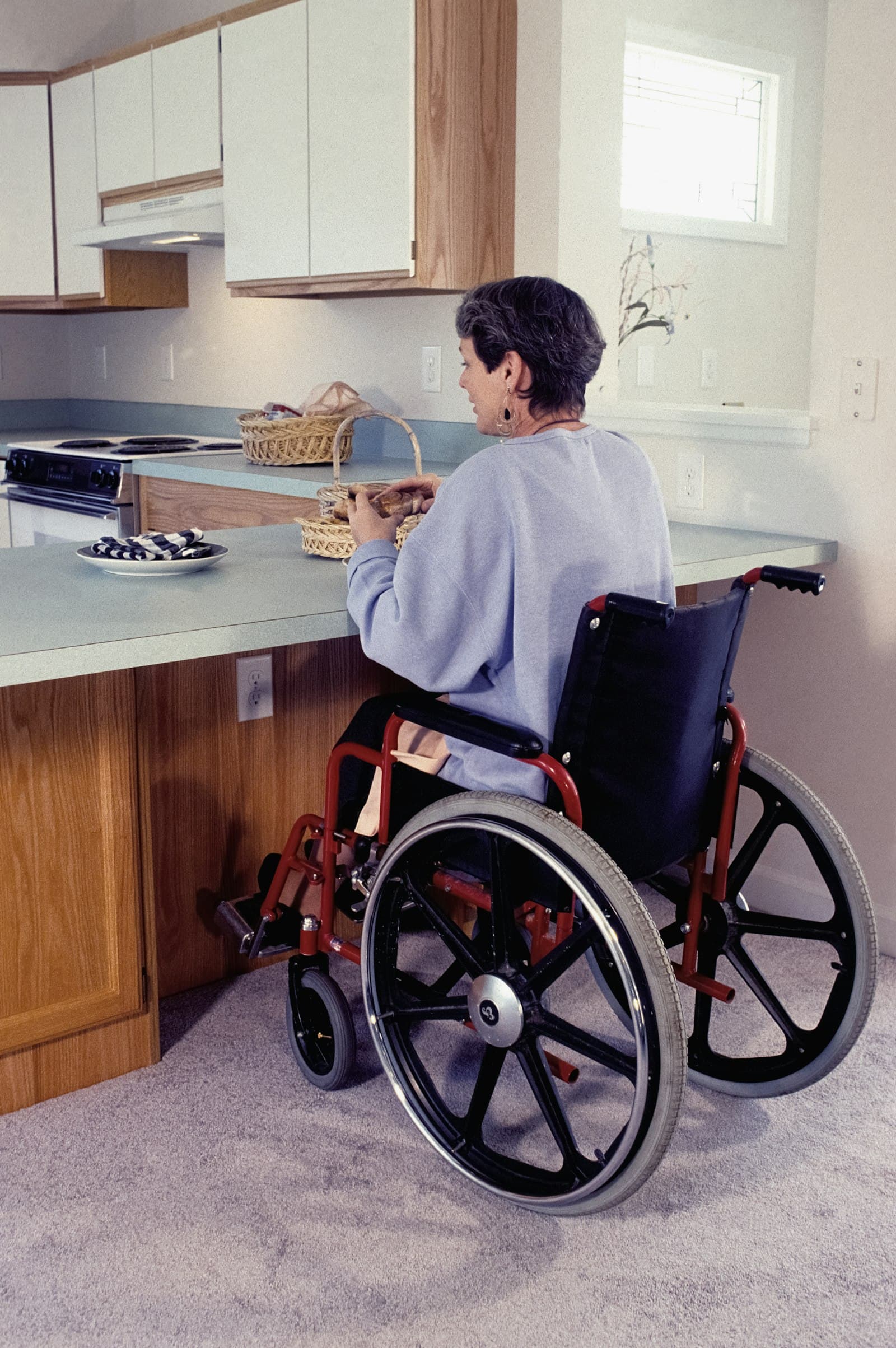 A woman using a wheelchair in her kitchen