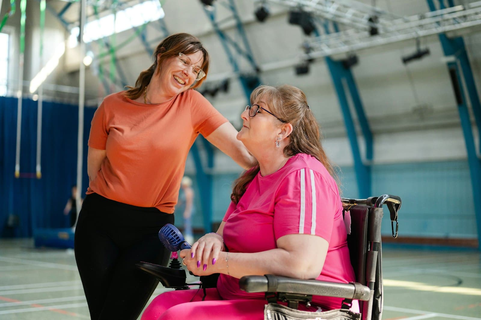 Two women talking in a community hall