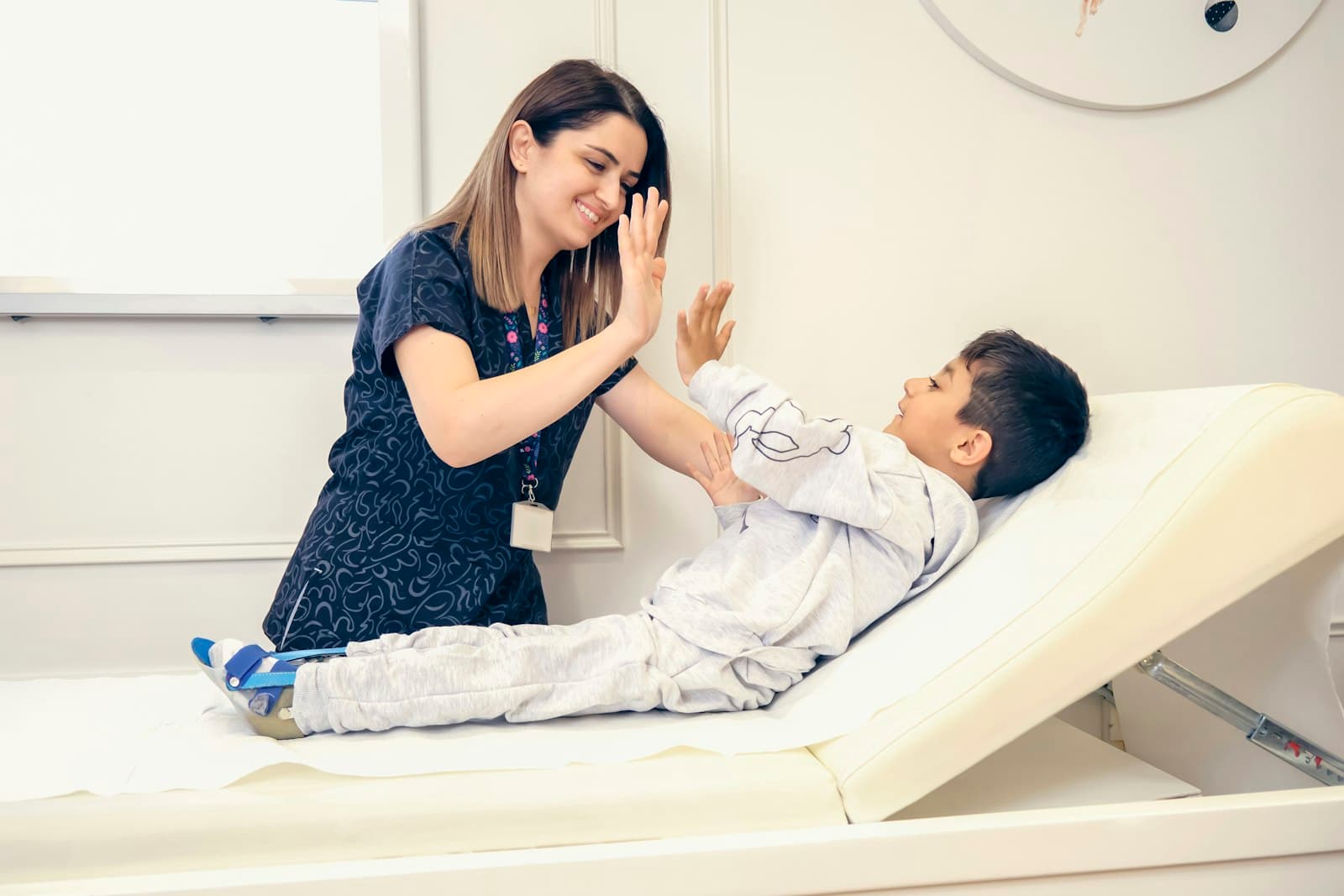 A therapist giving a boy a high five during a session