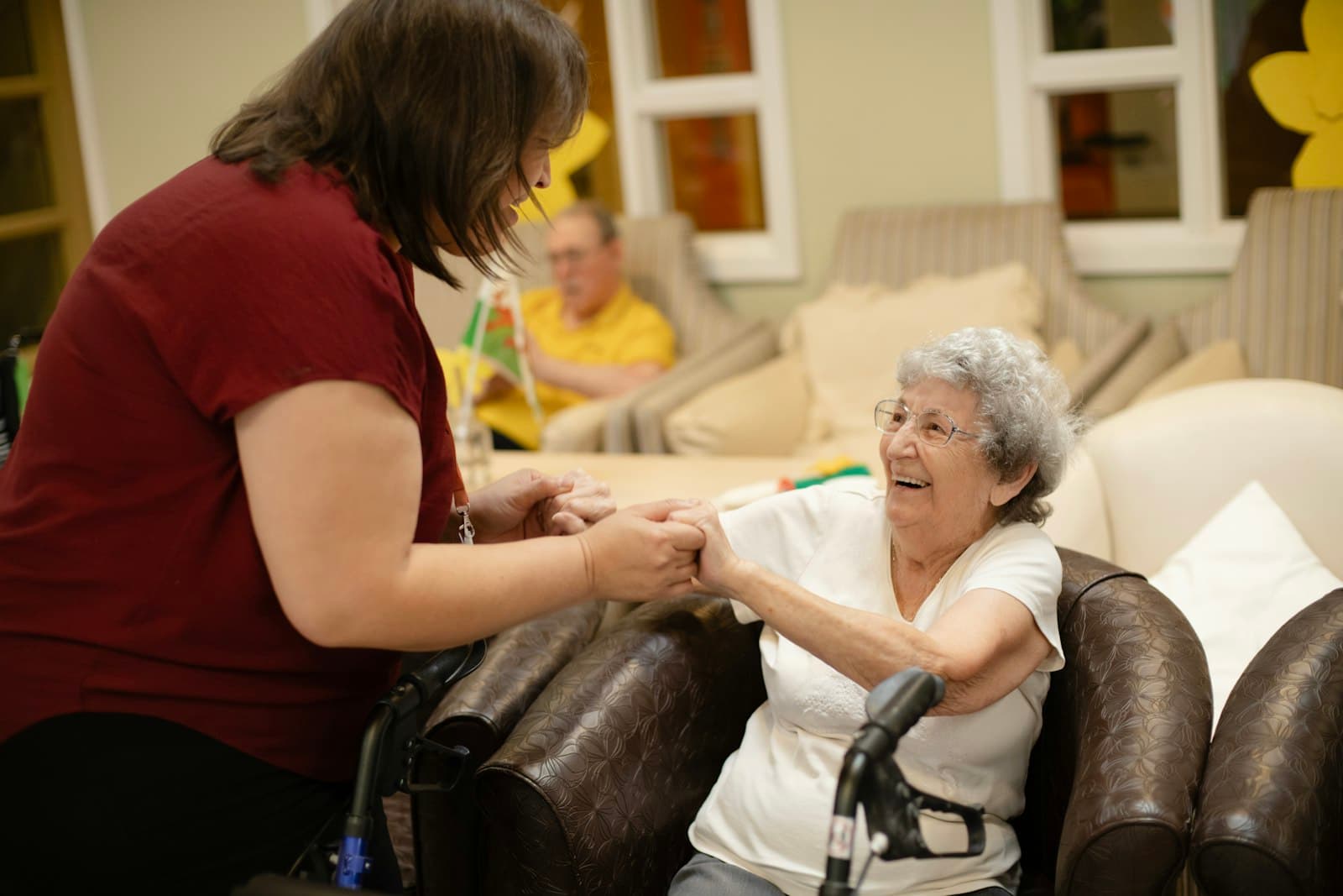 A support worker walking beside an older woman using a walking frame