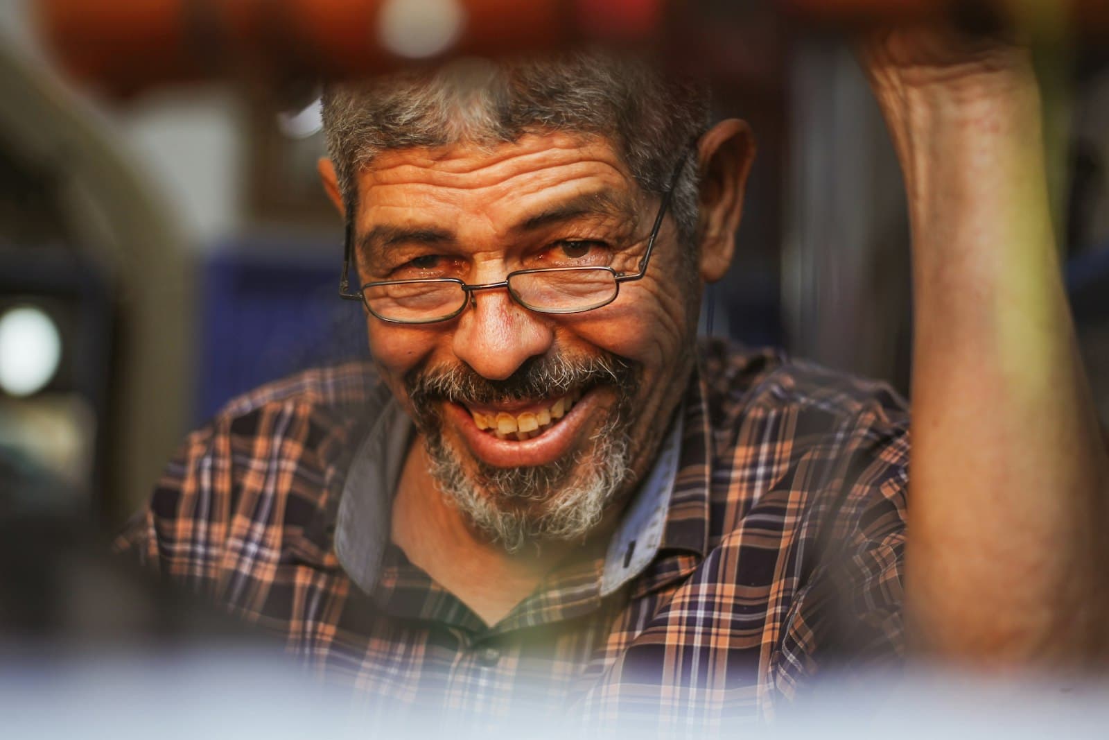 An older man with glasses smiling warmly