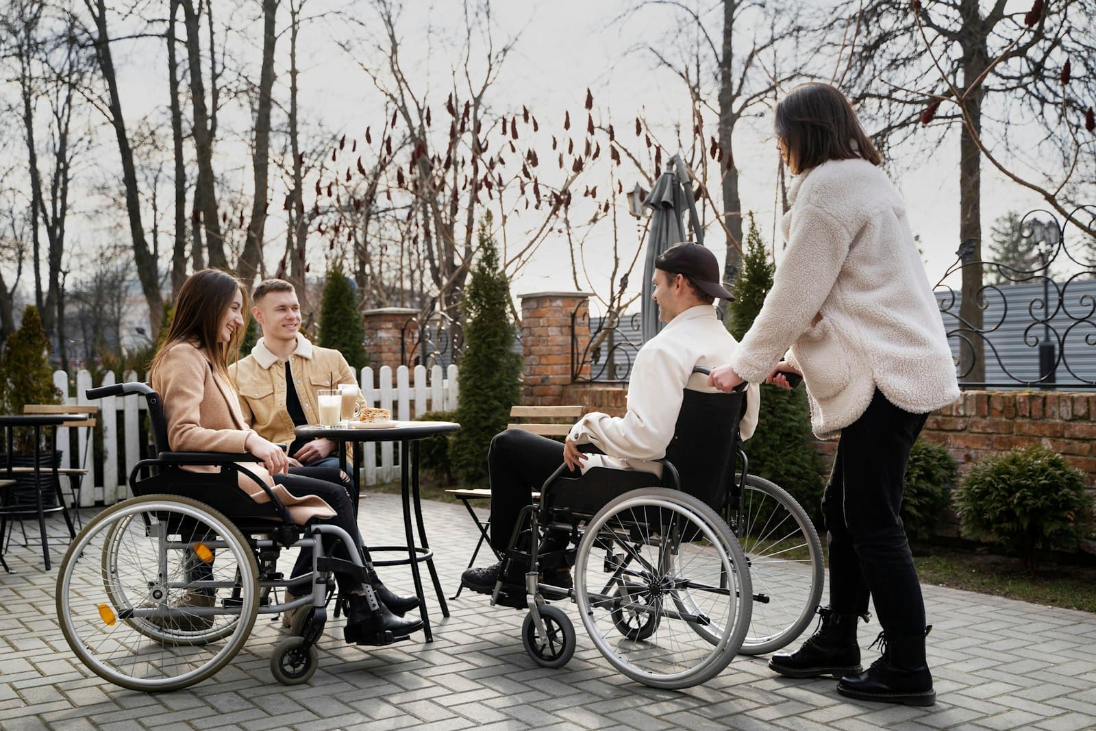 A group of people, some using wheelchairs, talking around a table